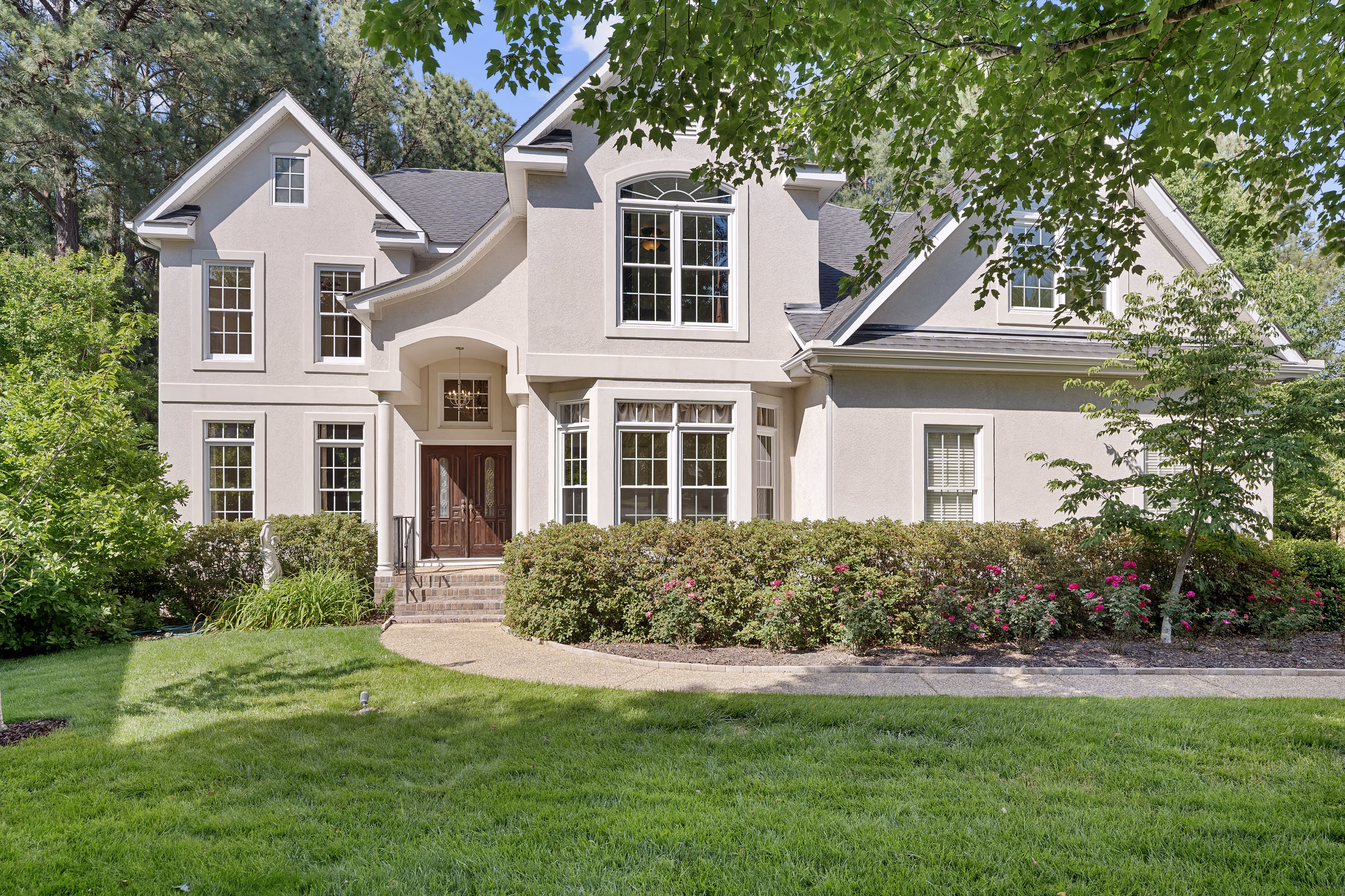 Elegant beige stucco home with manicured landscaping, ideal for sellers.