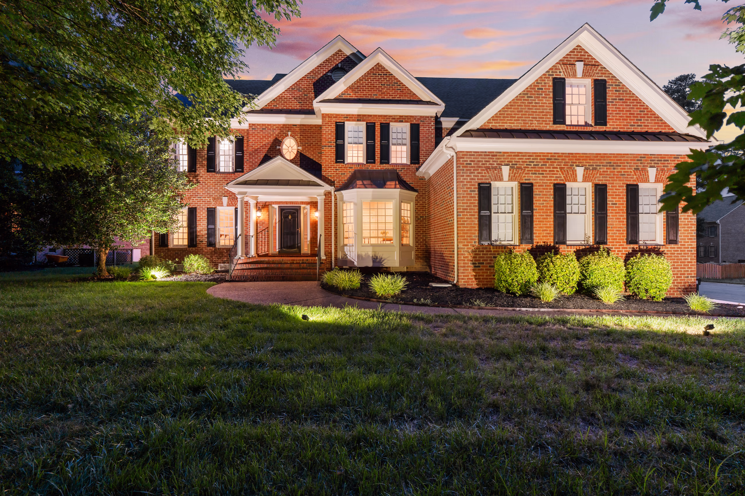Luxury brick home at sunset, ideal for sellers showcasing upscale properties.